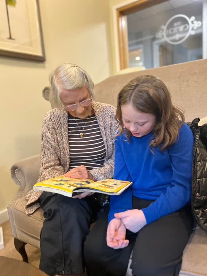 resident reading with girl from local school